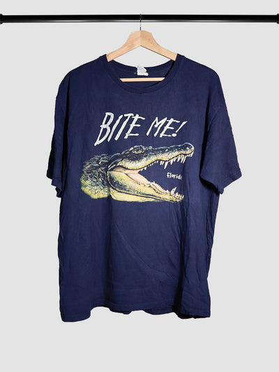Navy blue t-shirt that says "Bite Me" on the front with a crocodile head below it, and the state of Florida written in the crocodile mouth. 